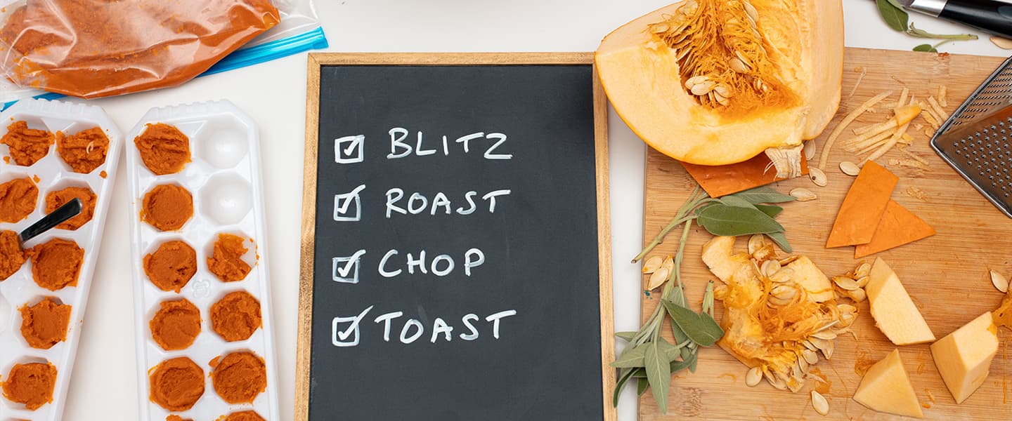 Pumpkin being cooked in various way on a kitchen counter, pureed in cupcake moulds, chopped on a chopping board. In the middle, a blackboard lists 'blitz, roast, chop, toast' with checkmarks in front of each word.