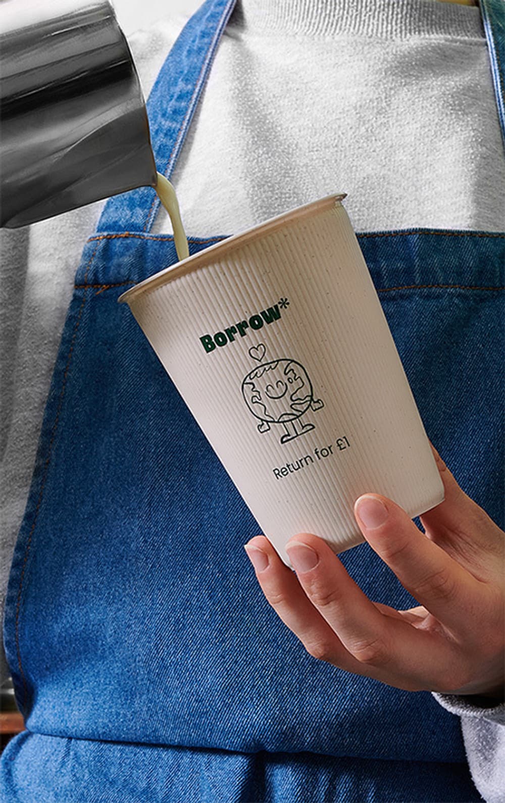 A coffee cup with "Borrow, return for £1" written on it, being filled with coffee.