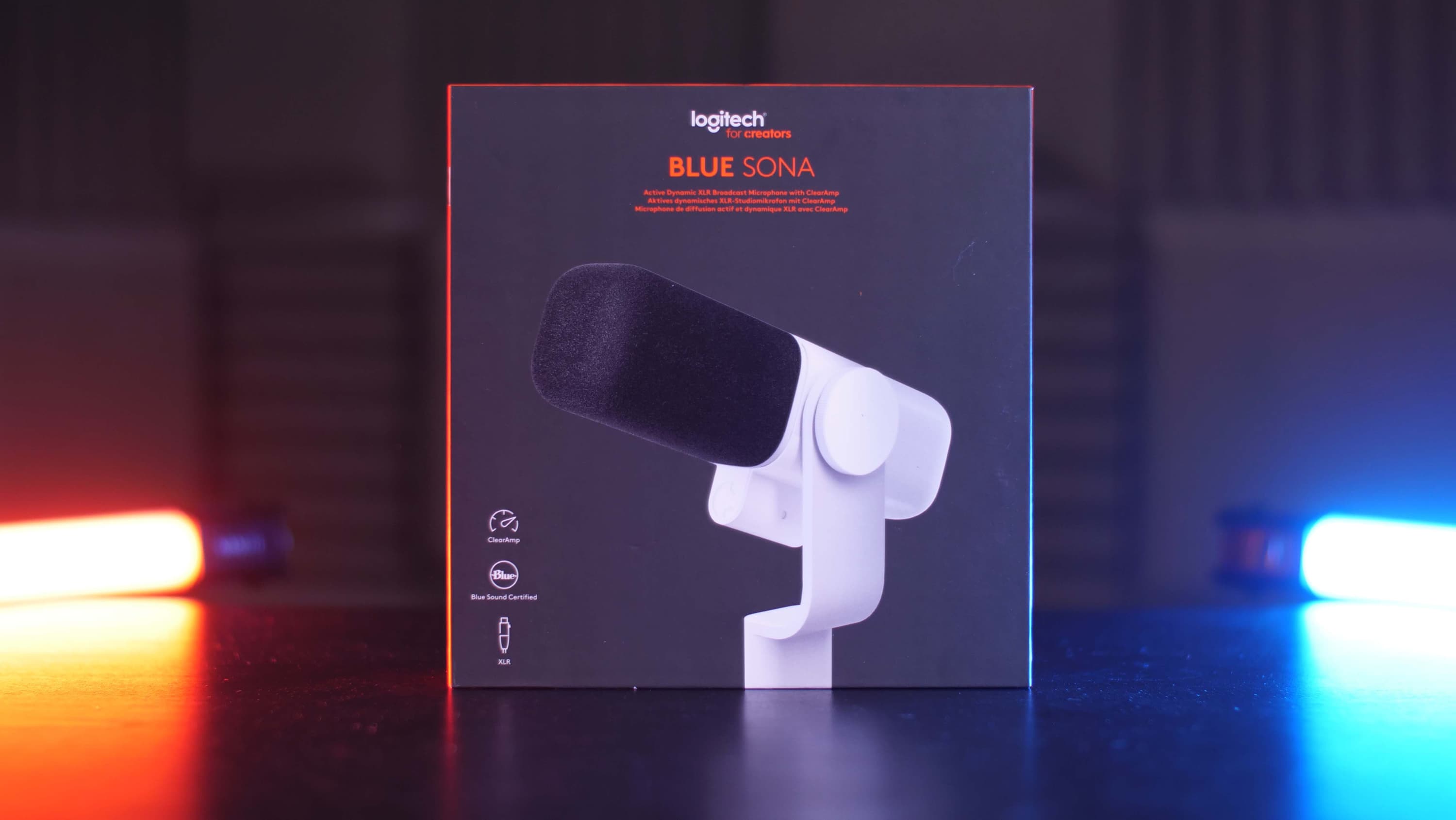 A Blue Sona Microphone box standing up right on a table.