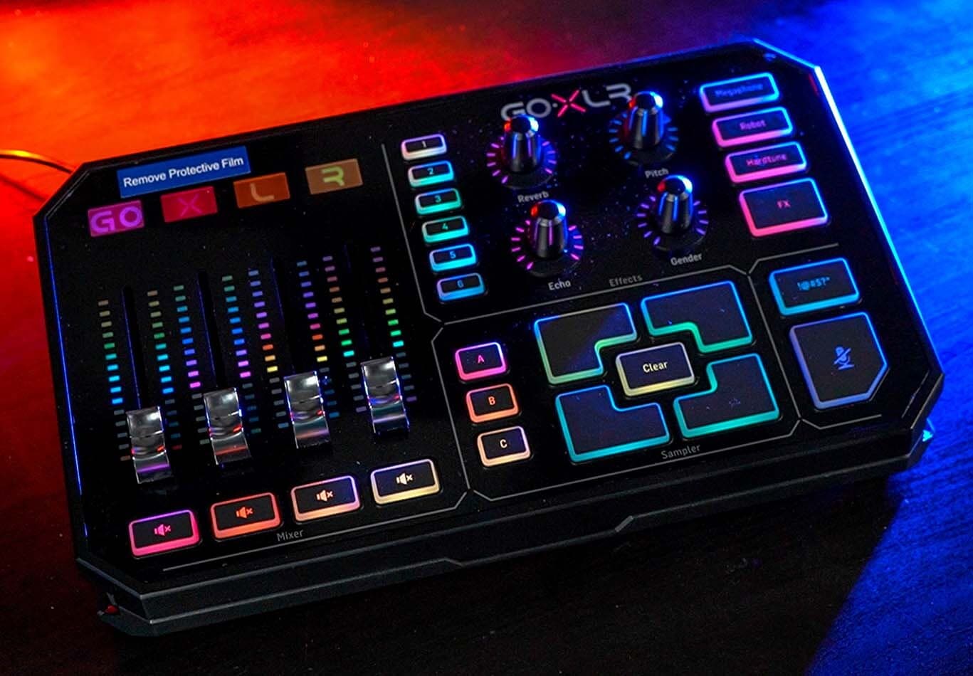 A lit up TC Helicon GoXLR mixer taken from slightly above and in front, with red and blue background lighting.