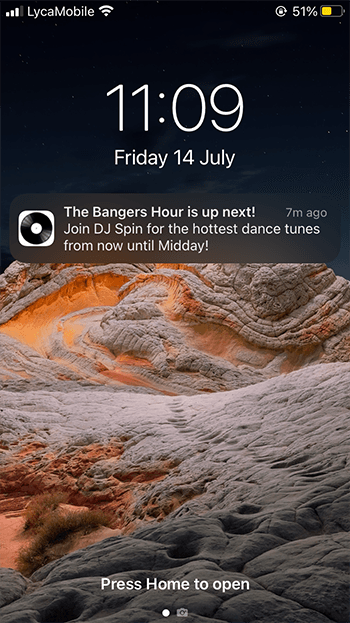 A screenshot showing an iOS homescreen, with a push notification on it that reads: The Bangers Hour is up next! Join DJ Spin for the hottest dance tunes from now until Midday!