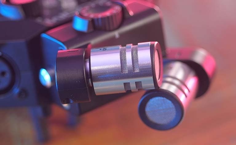 A close up of the XYH-6 microphones. They are small, have a silver metal casing and cylindrical shapes.