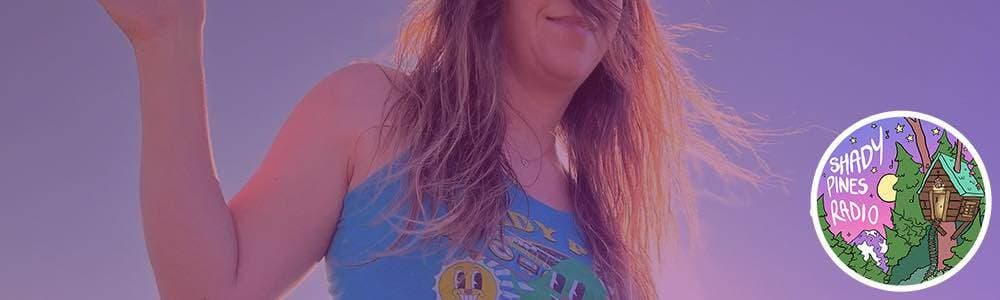 A shot of a white woman dancing, whilst wearing a Shady Pines vest top, taken from below. The Shady Pines Radio logo is in the bottom right-hand corner..