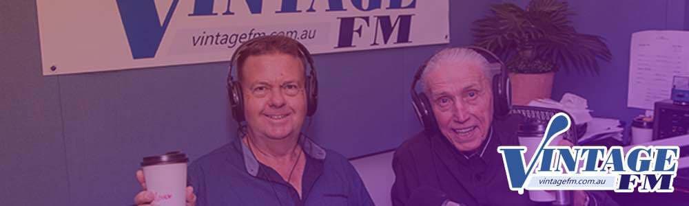 Two Vintage FM hosts, older white men, in the radio booth. There is the Vintage FM logo in the bottom right hand corner.