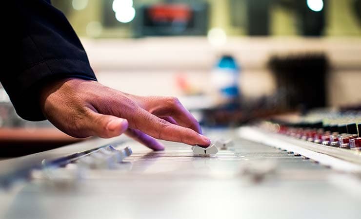 Radio presenter using the mixing desk.