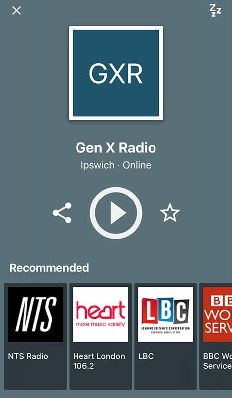 A grey background. In the middle of the screen is white buttons to share, play & favourite the station. Beneath is the text 