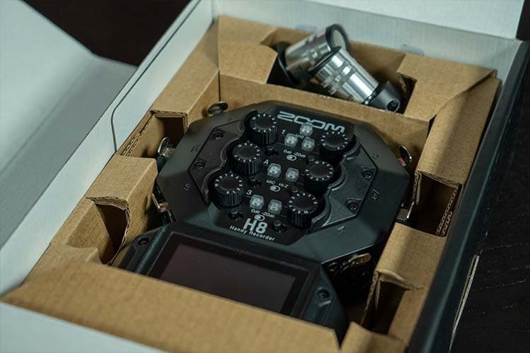 An open Zoom H8 box, showing the device and and the XYH-6 microphones nestled in cardboard.