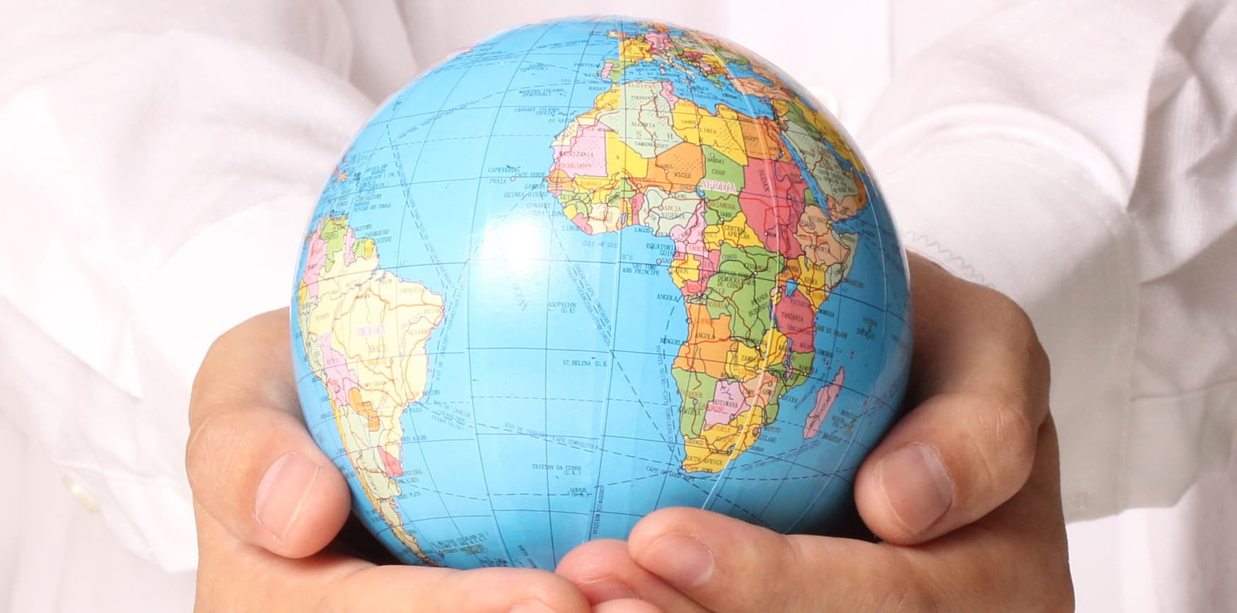 A person holding a globe in their hands.