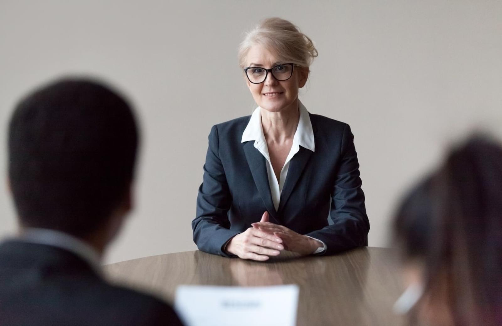 Smiling middle aged female job applicant making first impression at interview