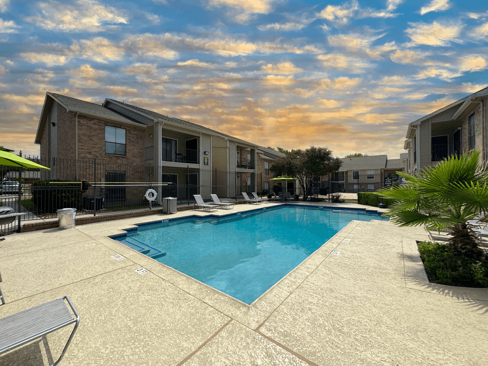 Village Green apartments Large pool in center of community with lounge chairs