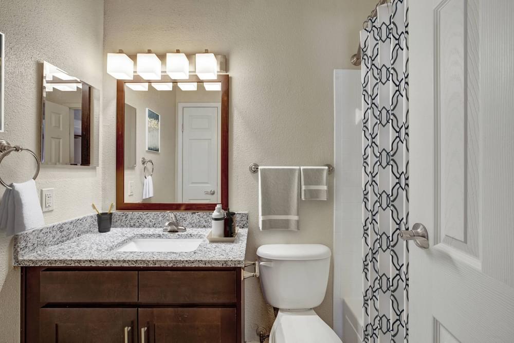 Village Green apartments Full unit bathroom with granite counter sink, toilet, and shower/bath.