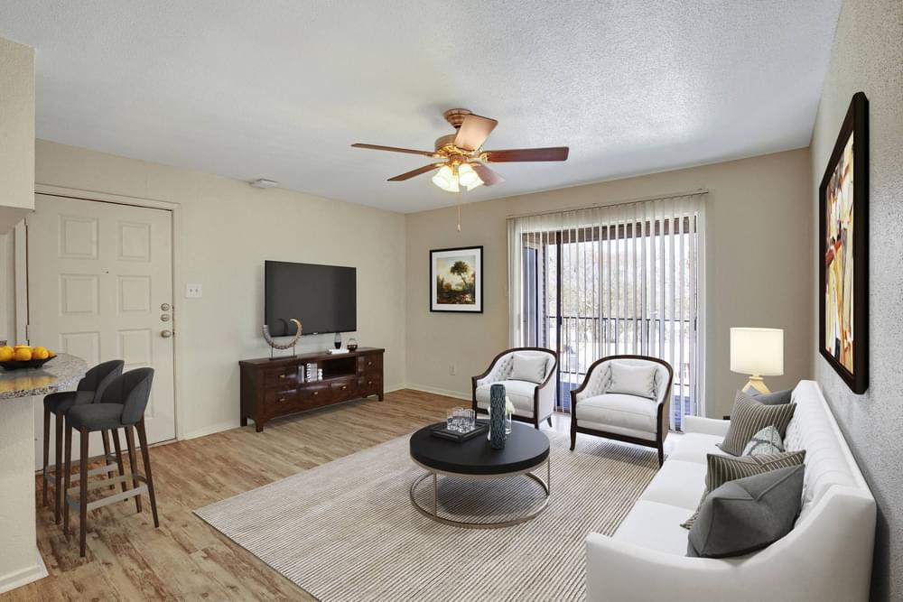 Village Green apartments Open layout living area with space for hosting, wooden flooring, and a large glass floor to private balcony.