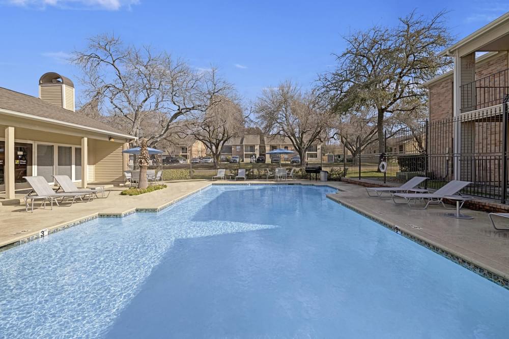 Village Green apartments Large pool in center of community with lounge chairs