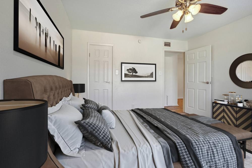 Village Green apartments Spacious bedroom with large window, carpet, and fan.