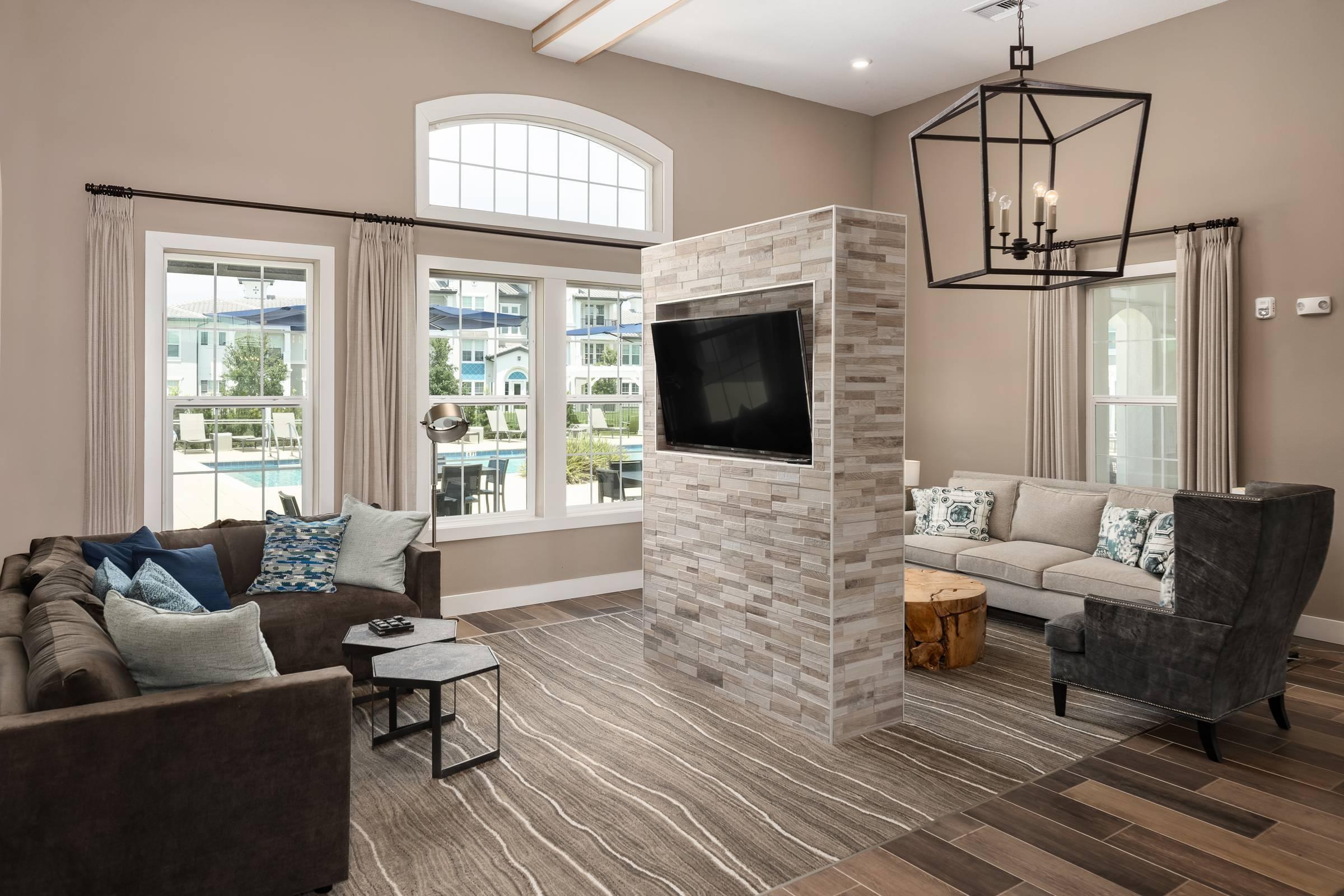 Shadetree Apartments clubhouse and lounge with beautiful and stylish furnishings, a TV, abundant natural light
