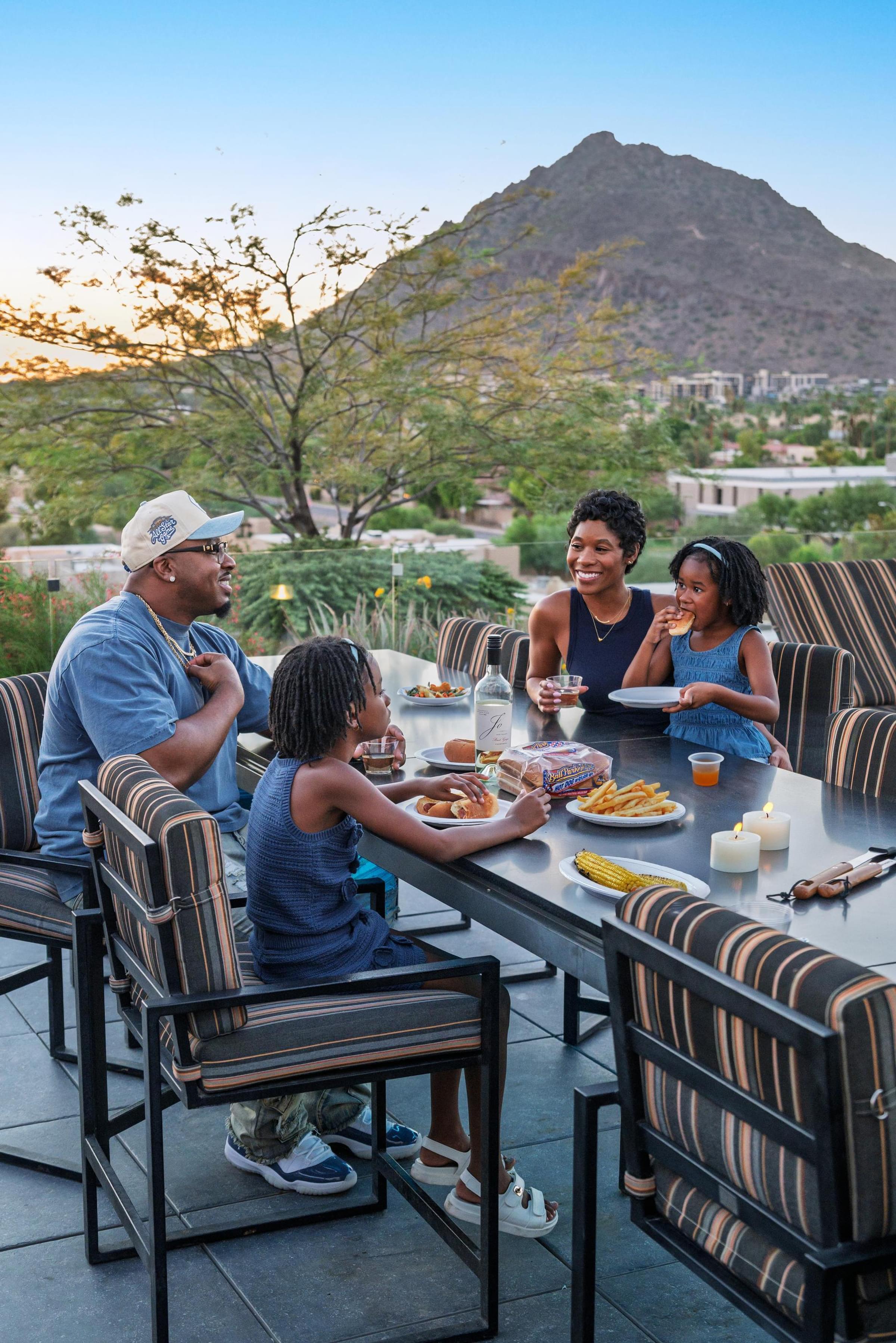 Optima Sonoran Village apartments a group of people sitting at a table with food and a mountain in the background.