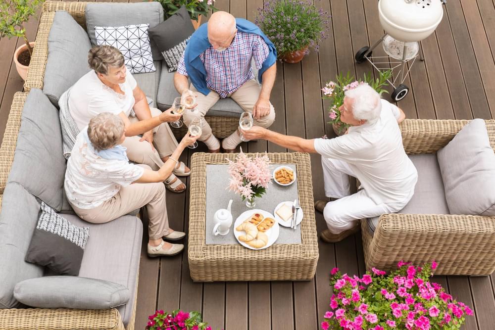 The Ensley seasonal screened porches with an elder man and woman enjoying lunch and wine together