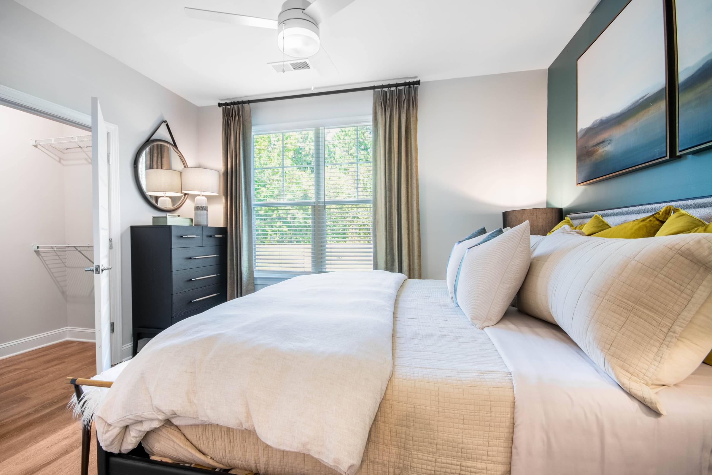 A bedroom with a large bed and a ceiling fan.