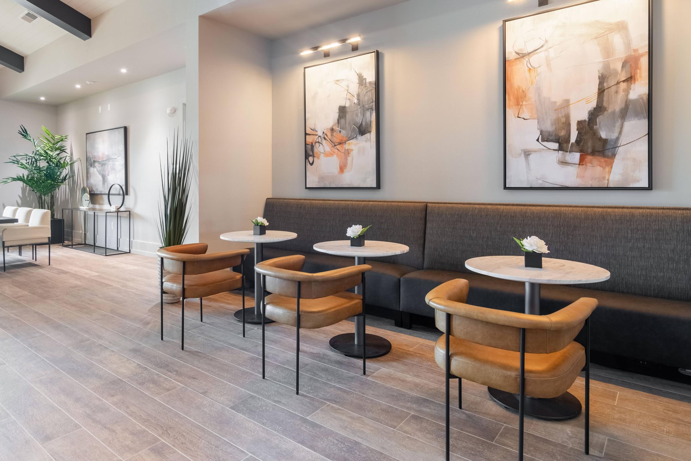 a seating area with tables and chairs in a lobby