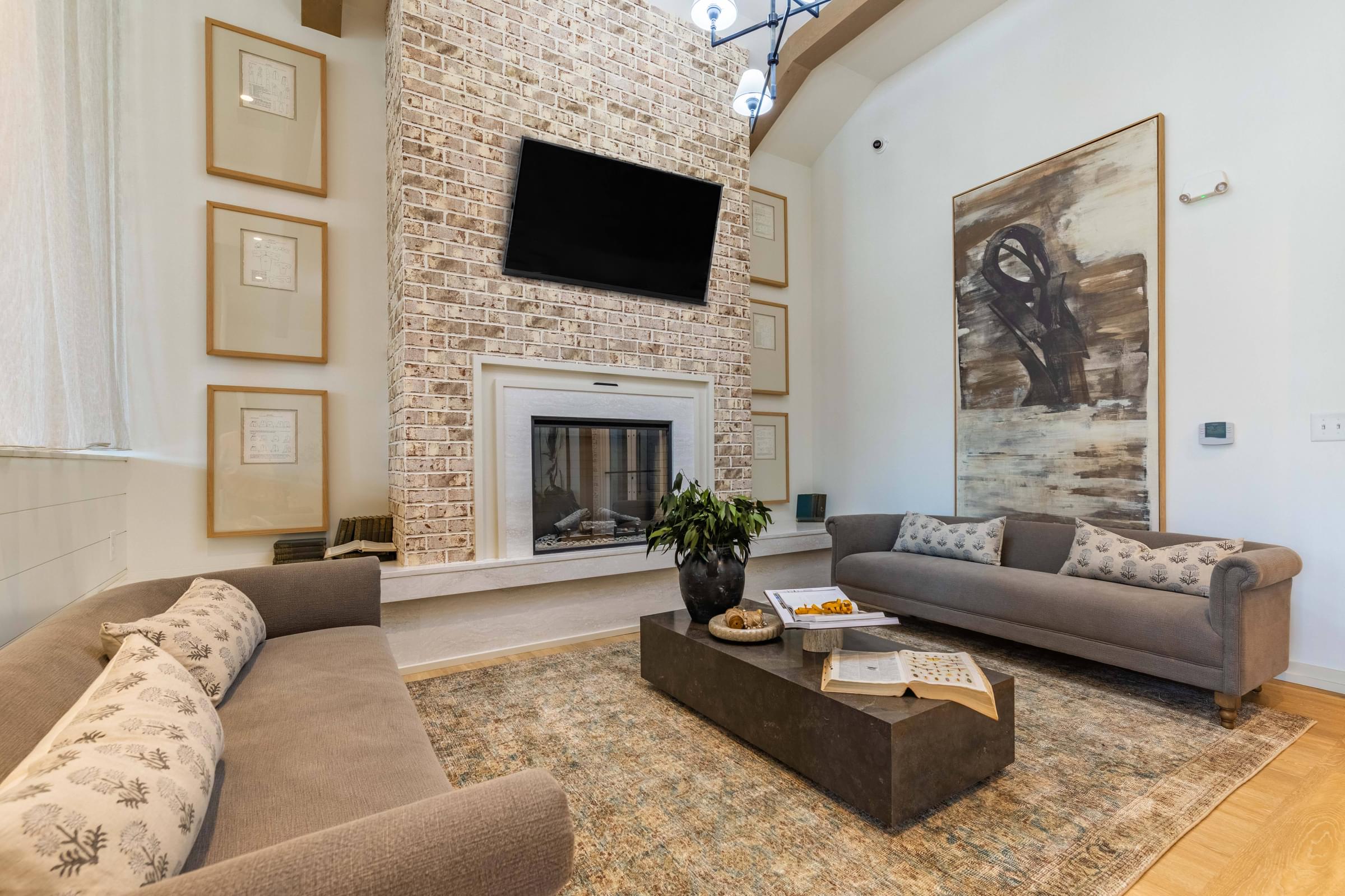 a living room with two couches and a fireplace    and a television