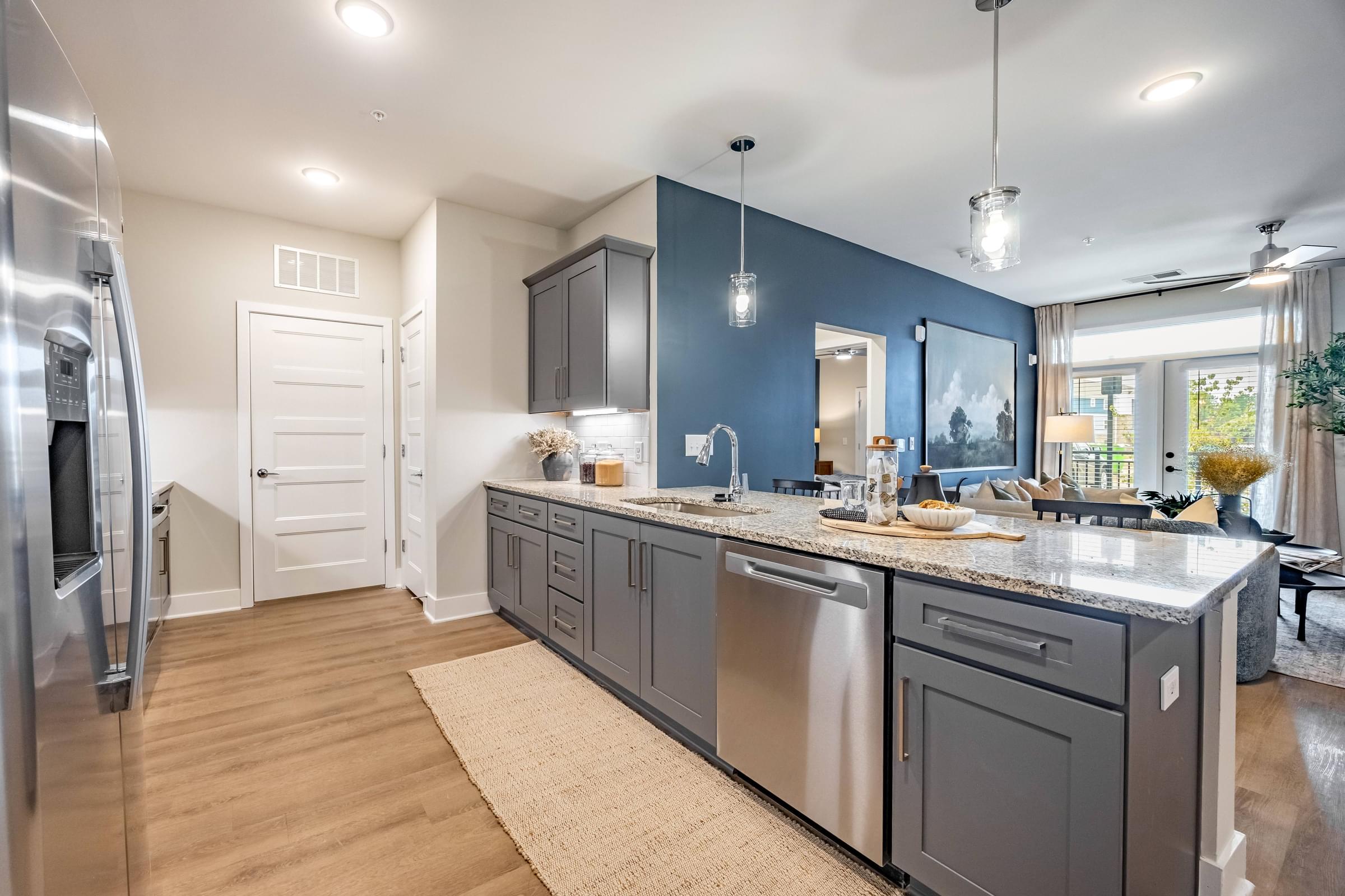 an open kitchen with stainless steel appliances and a blue accent wall