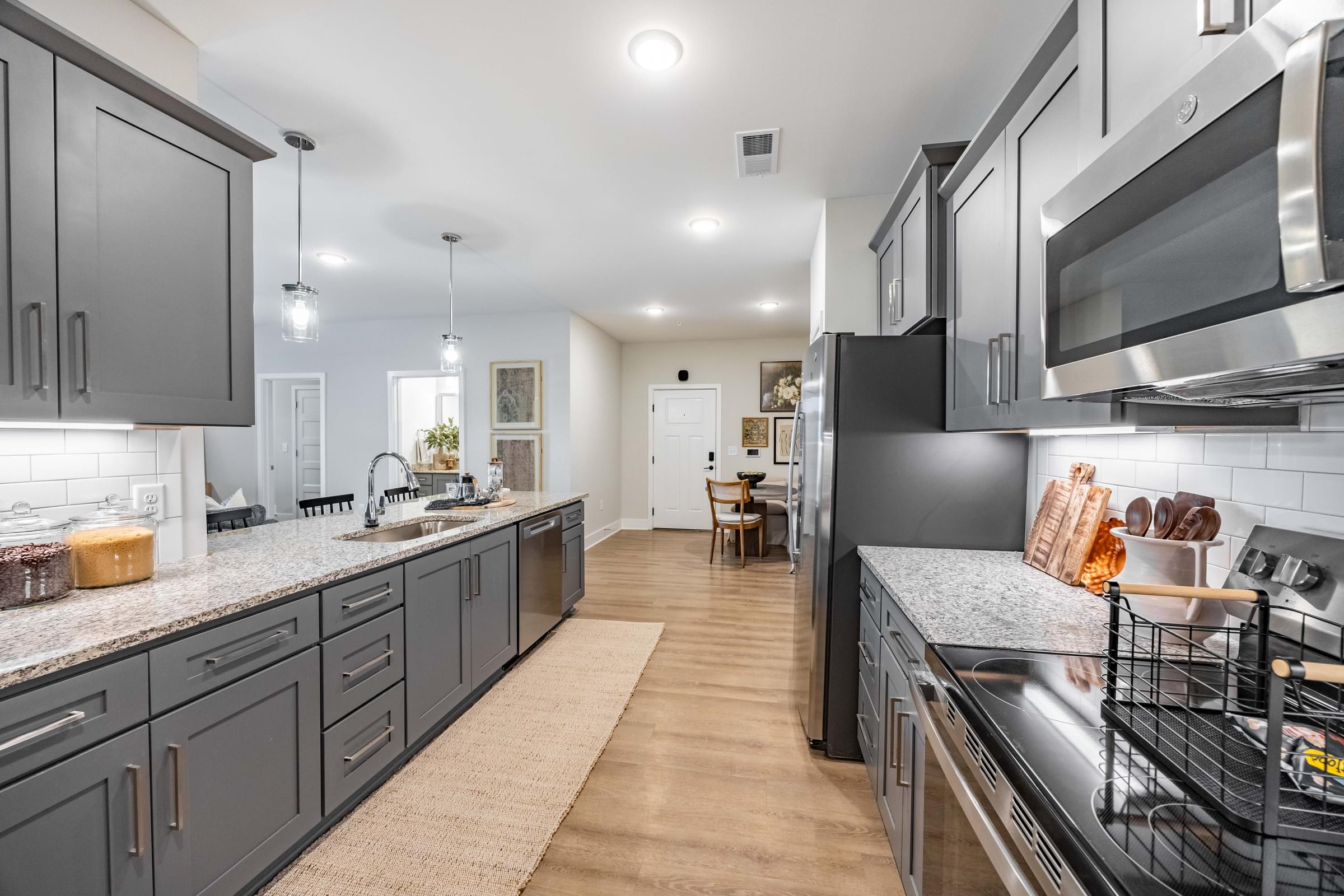 a large kitchen with stainless steel appliances and gray cabinets