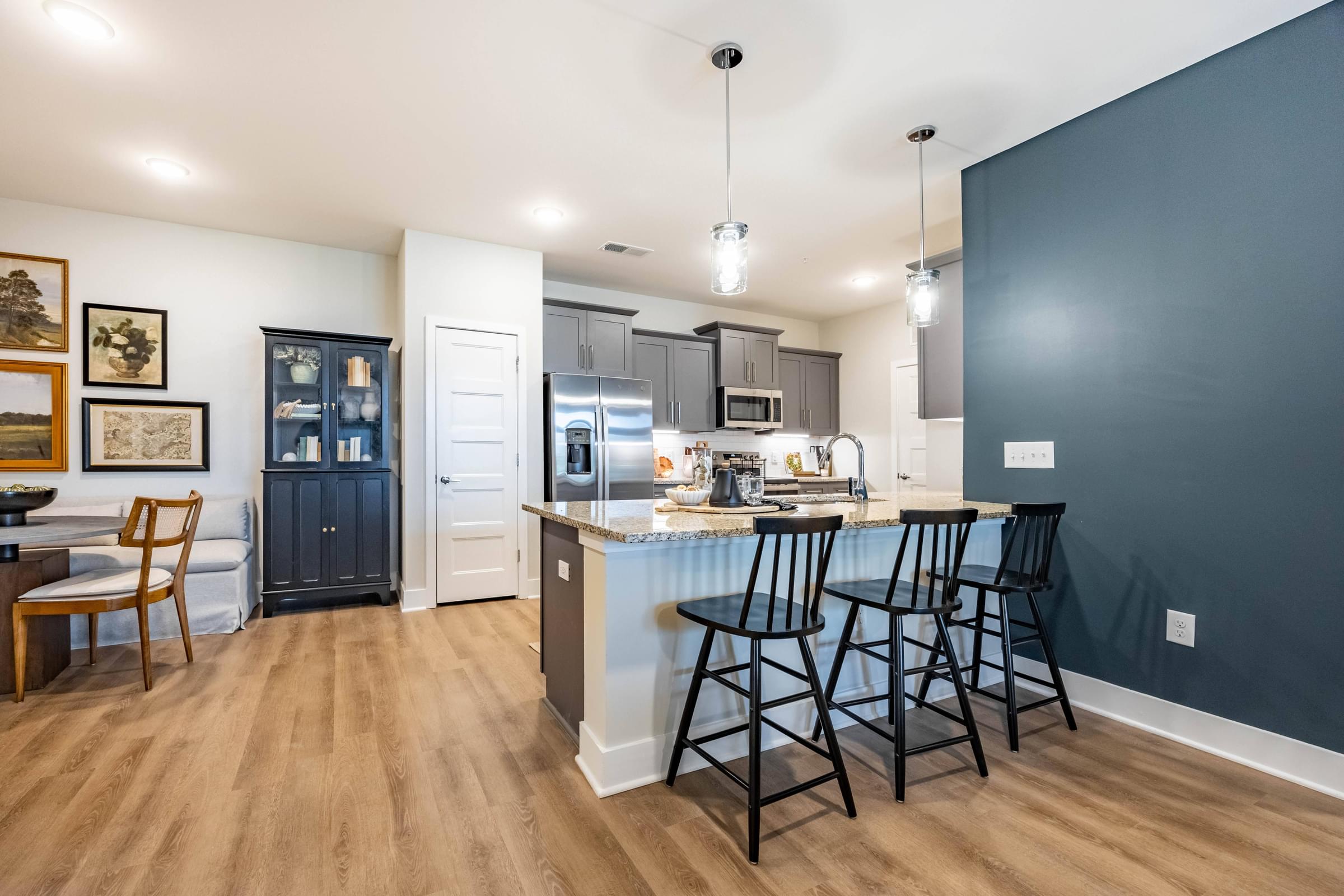 a kitchen with a bar and stools in front of a kitchen island with a