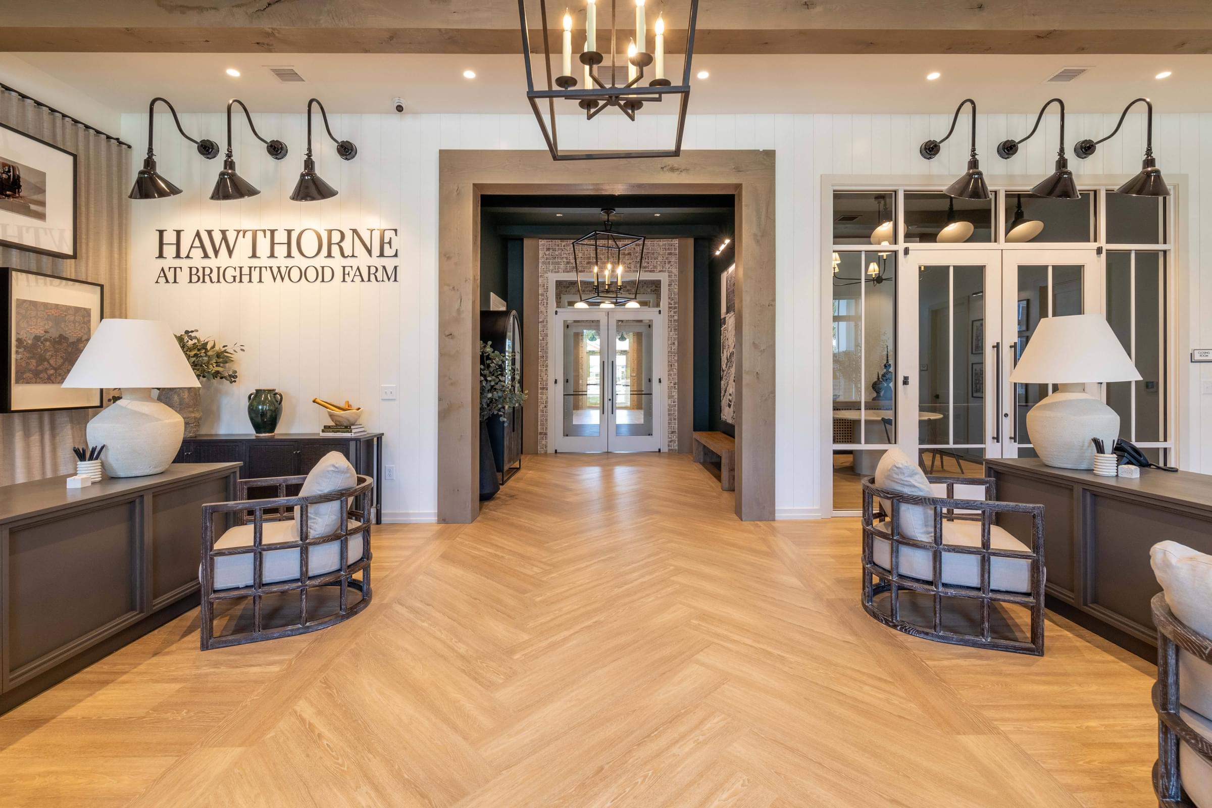 A well-lit room with a wooden floor and a chandelier hanging from the ceiling.