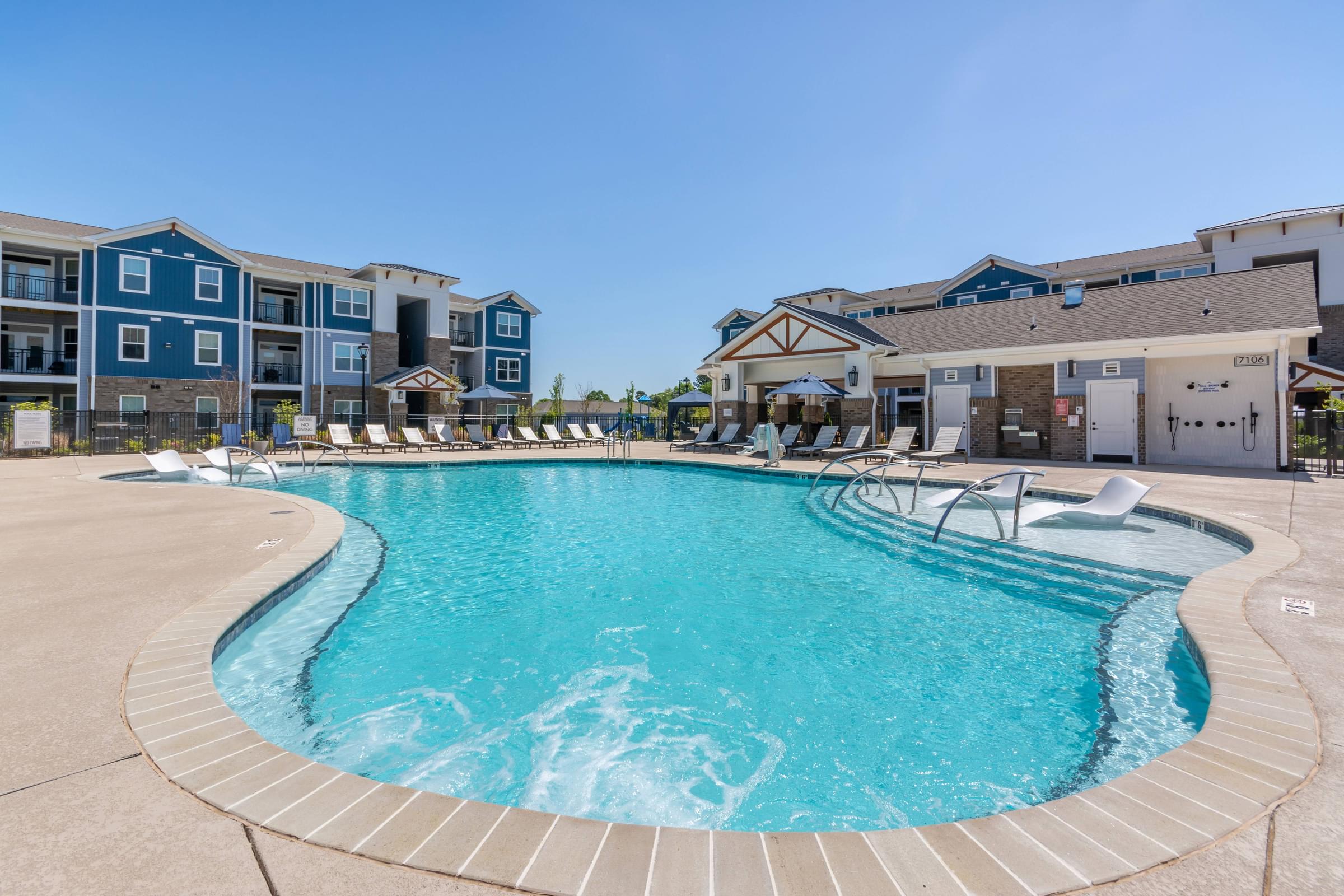 A large swimming pool in front of apartment buildings.