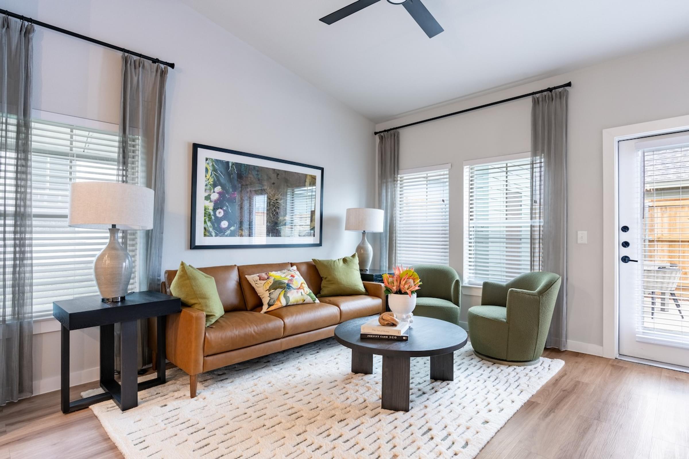 A living room with a brown couch, a coffee table, and a painting on the wall.