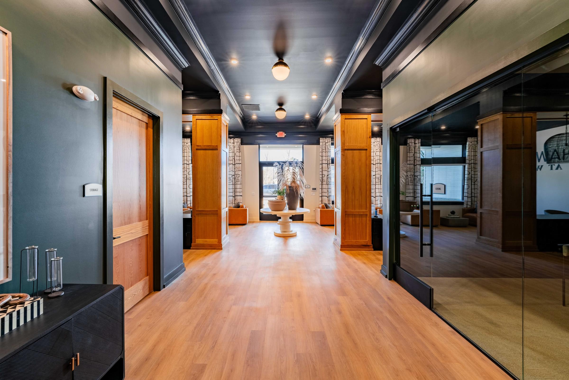 A long hallway with wood floors and a black ceiling.