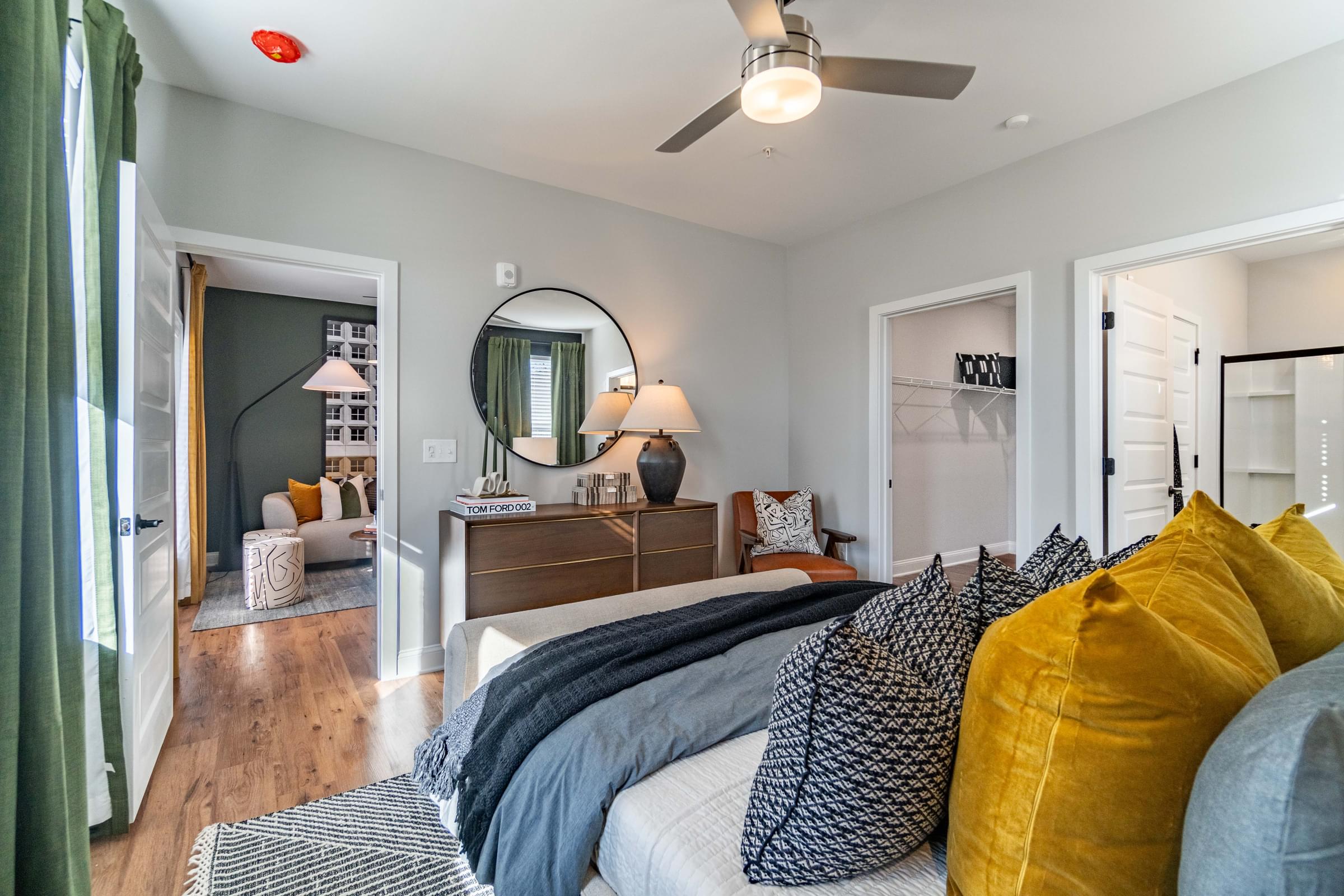 A bedroom with a bed, a dresser, and a mirror.