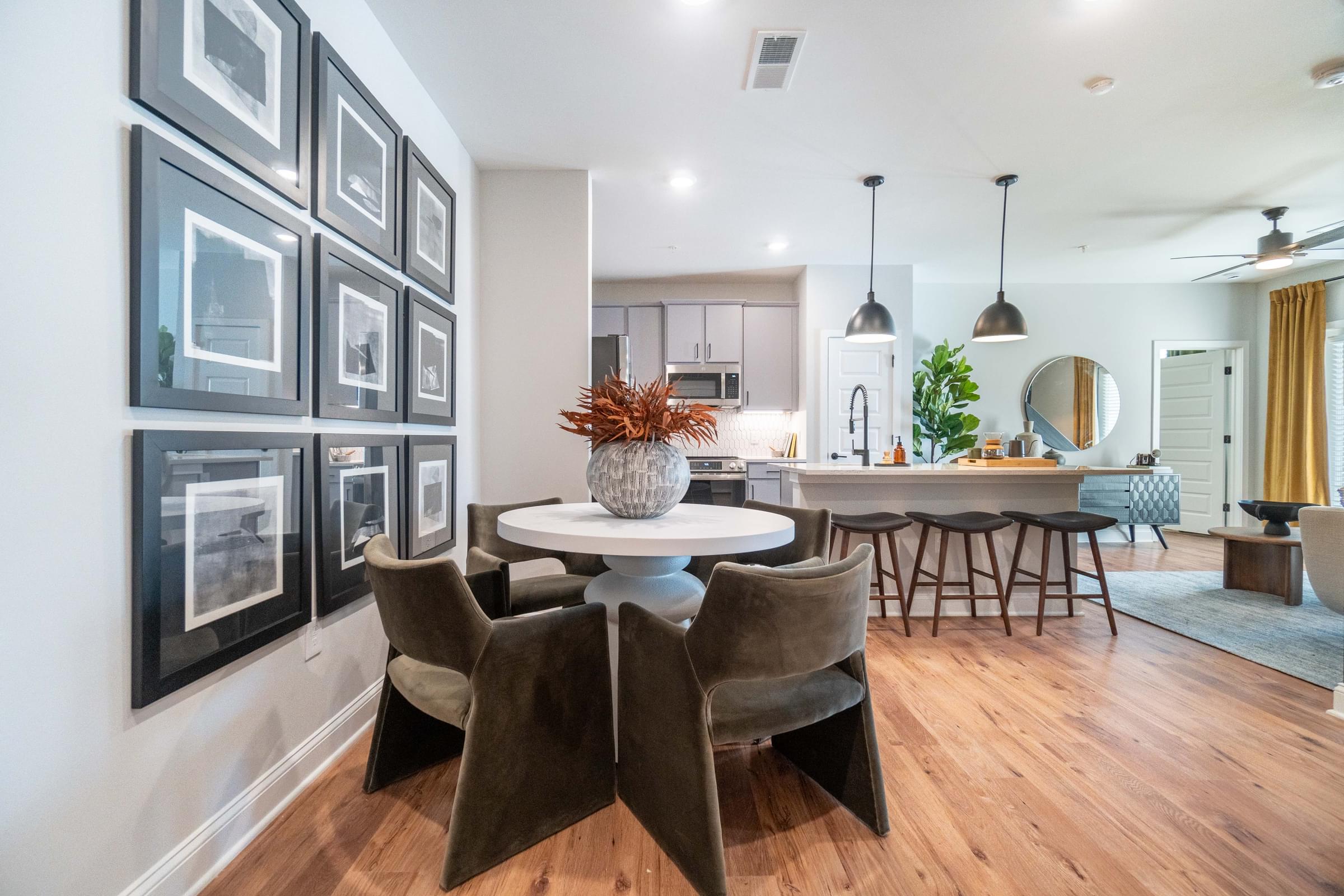A dining room with a white table and brown chairs.