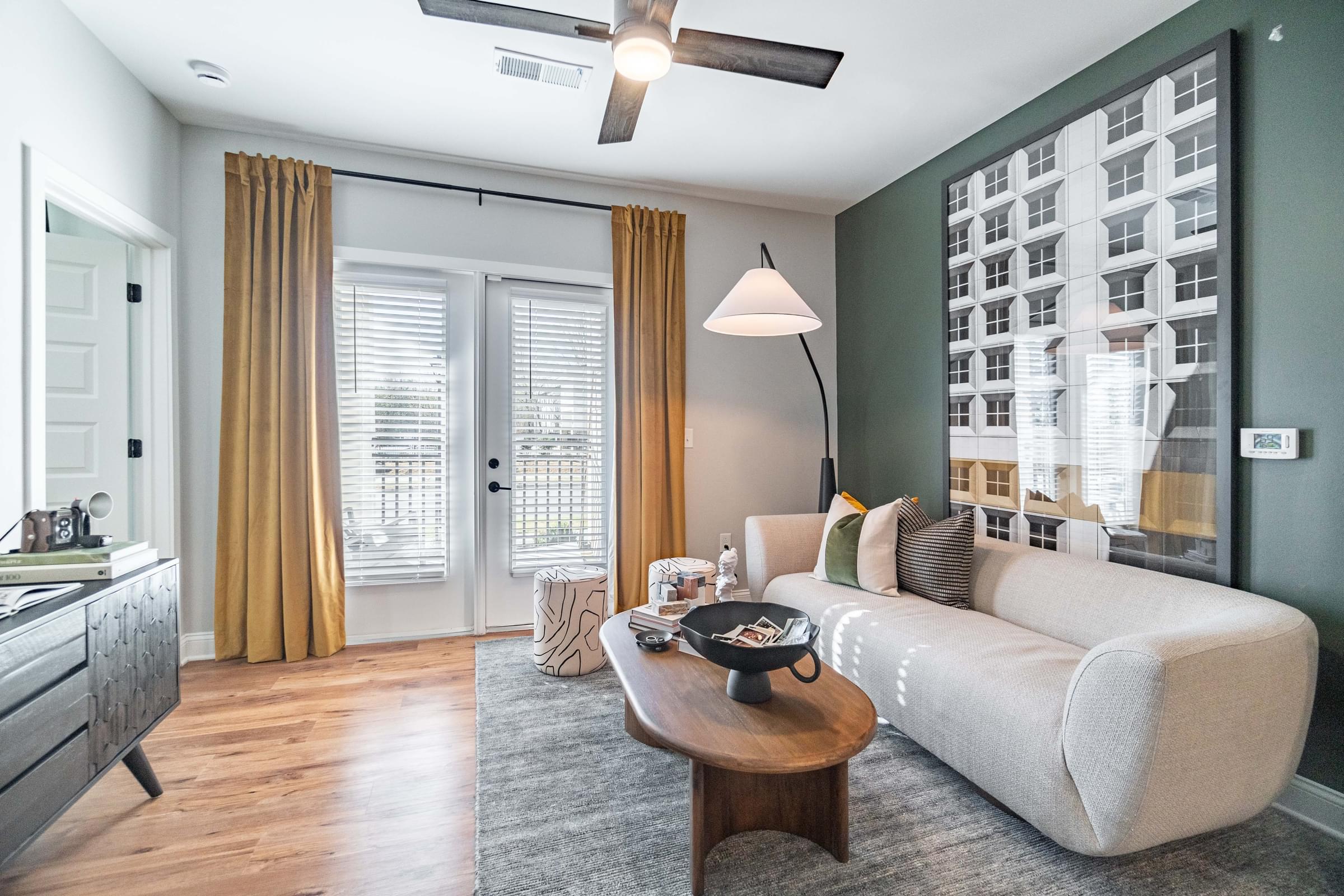 A living room with a white couch, a coffee table, and a ceiling fan.