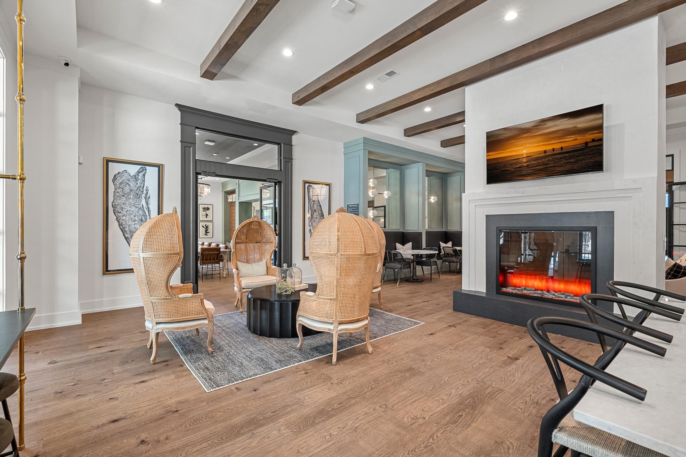 clubhouse modern living room with a fireplace and four chairs for seating.