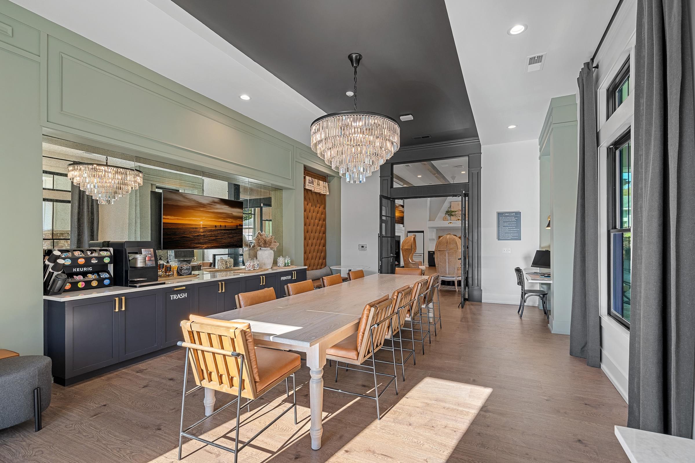 A modern kitchen with a long dining table and multiple chairs for seating.
