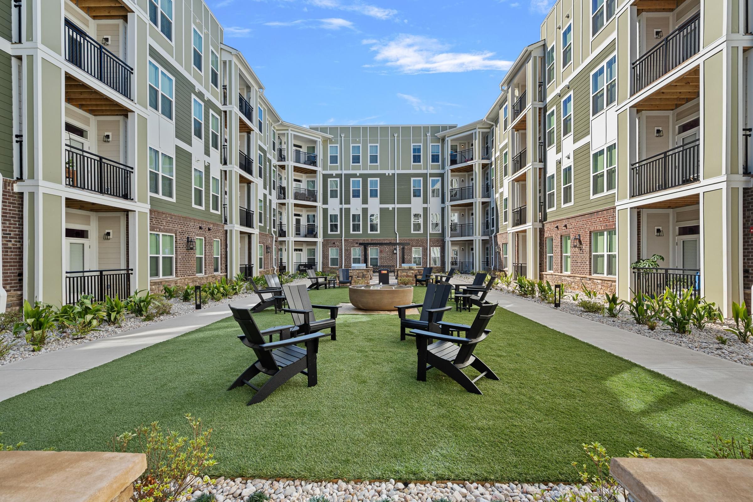 Center of the courtyard with a lawn and four chairs for sitting.