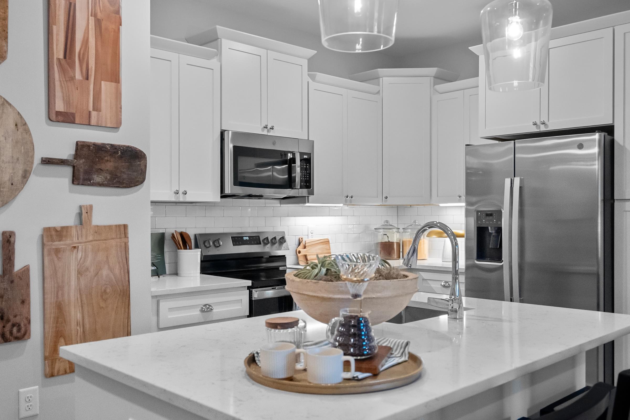A modern kitchen with white cabinets and white countertop.