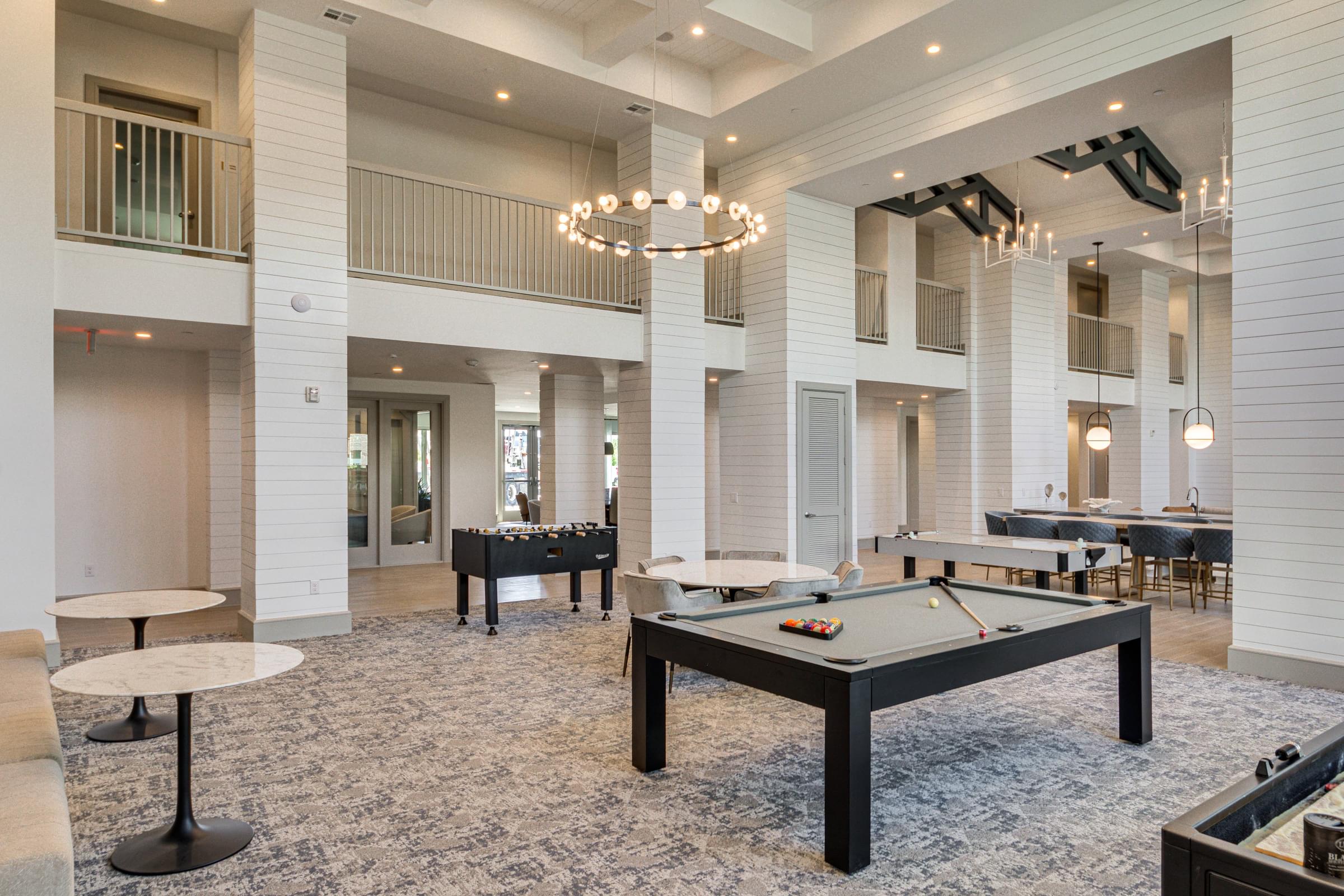 a clubhouse with a pool table and tables