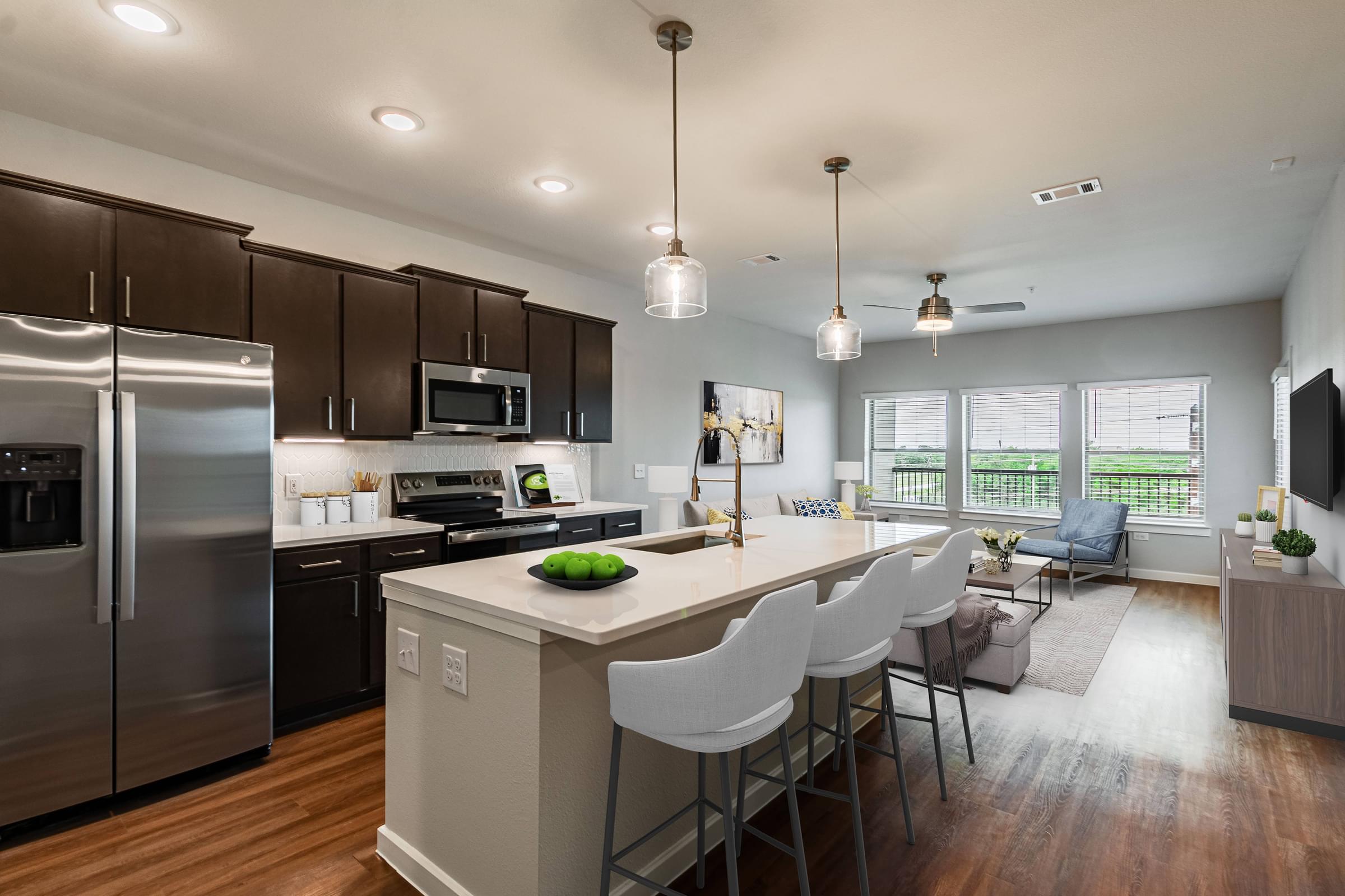 a kitchen and living room with a large island and stainless steel appliances