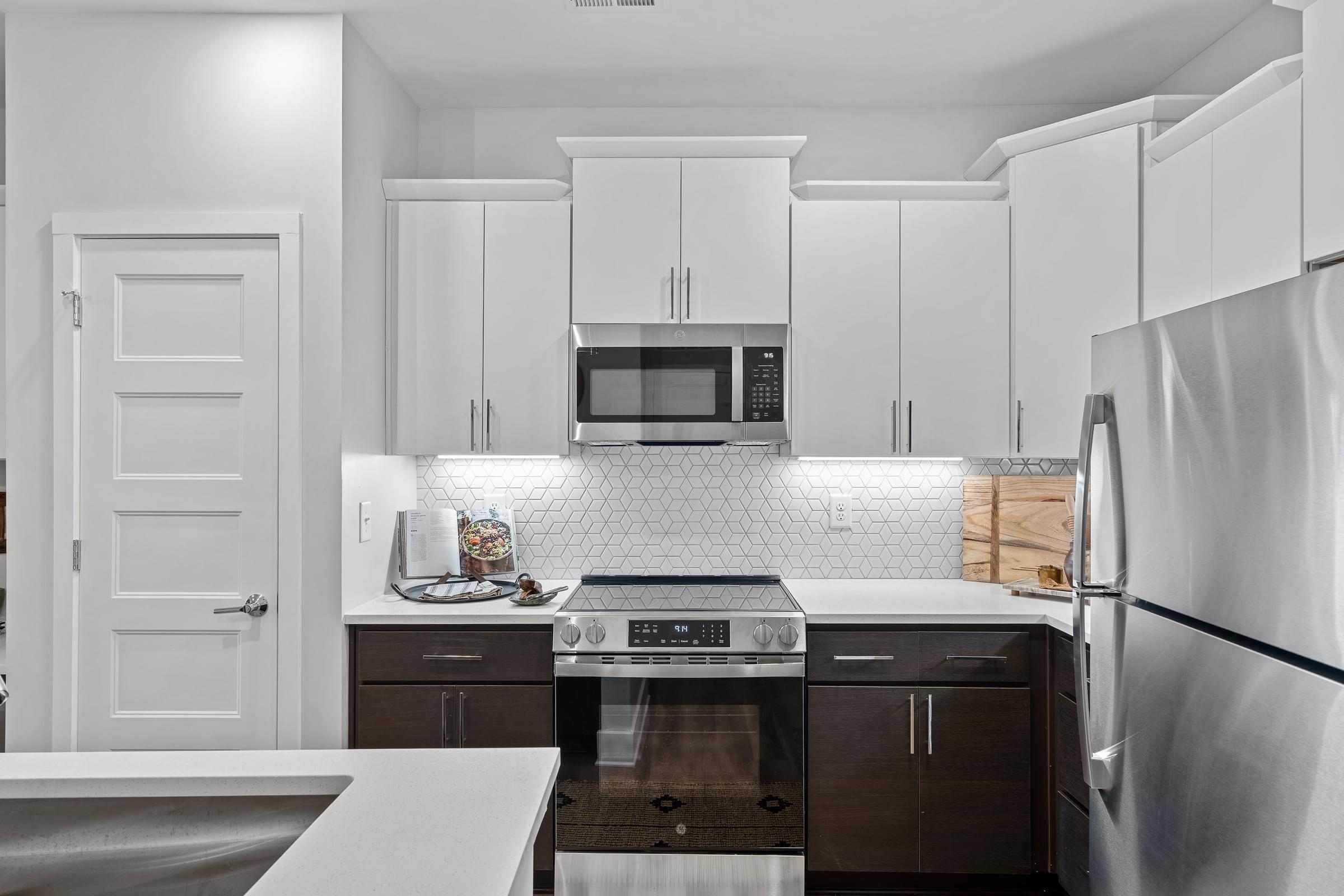 A kitchen with white cabinets and black appliances.
