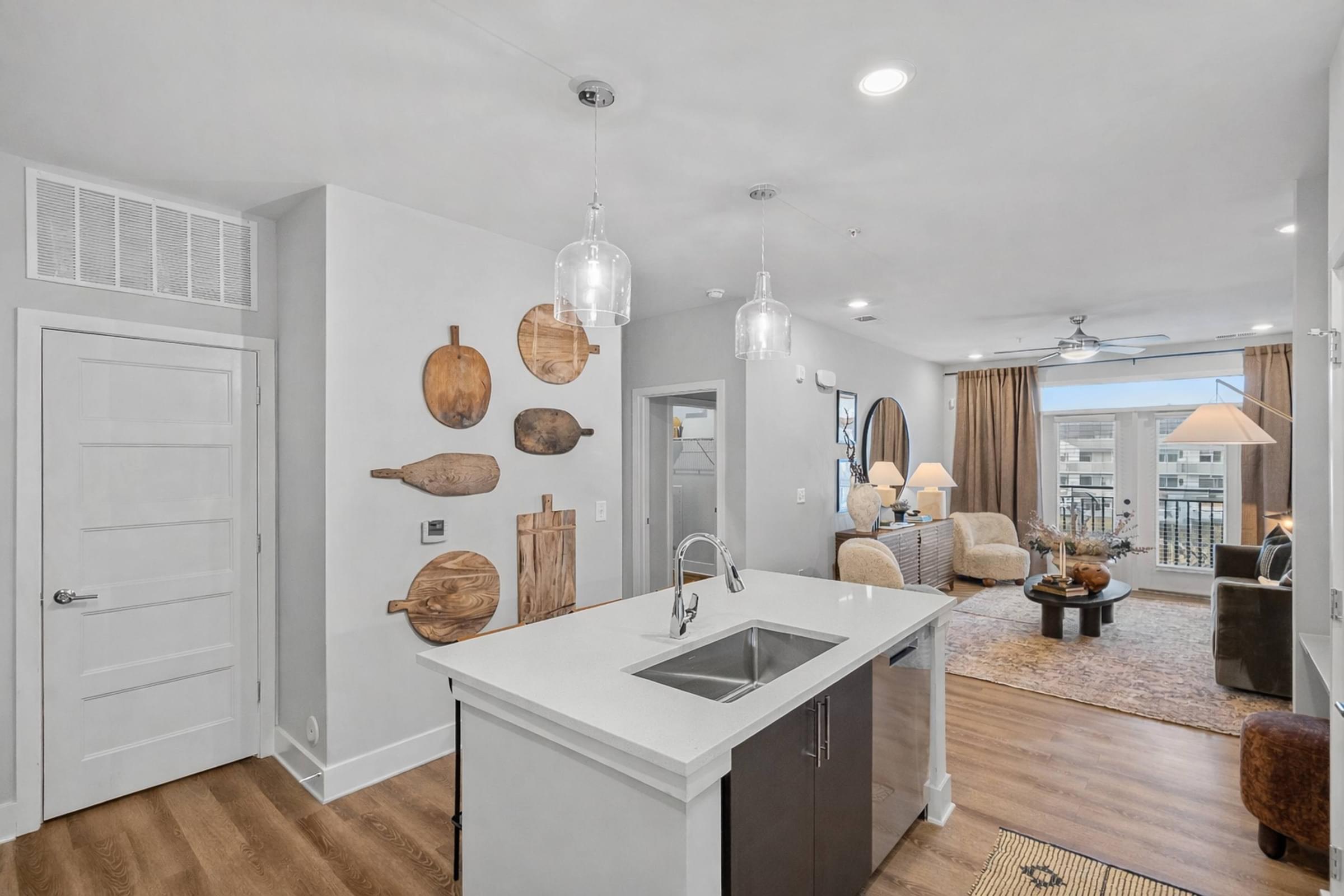 A kitchen with a white counter top and wooden wall decorations.