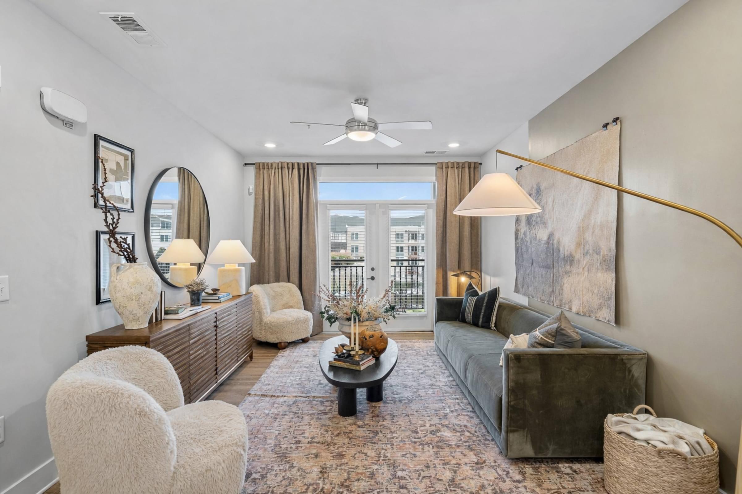 A living room with a grey couch, a coffee table, and a large painting on the wall.