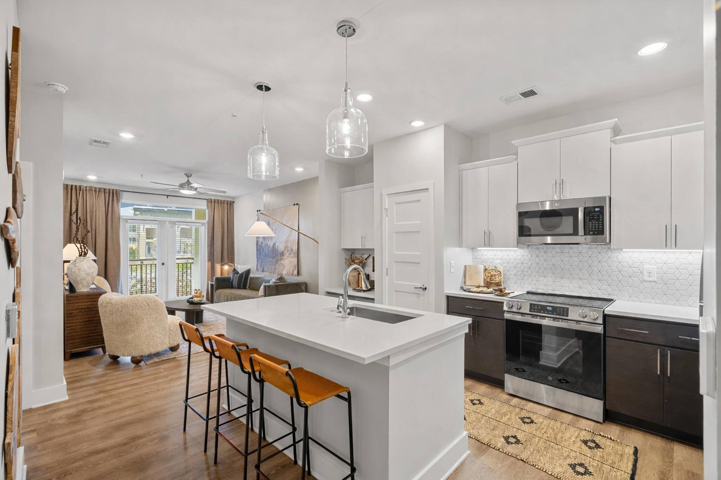 A kitchen with a white island and black cabinets.