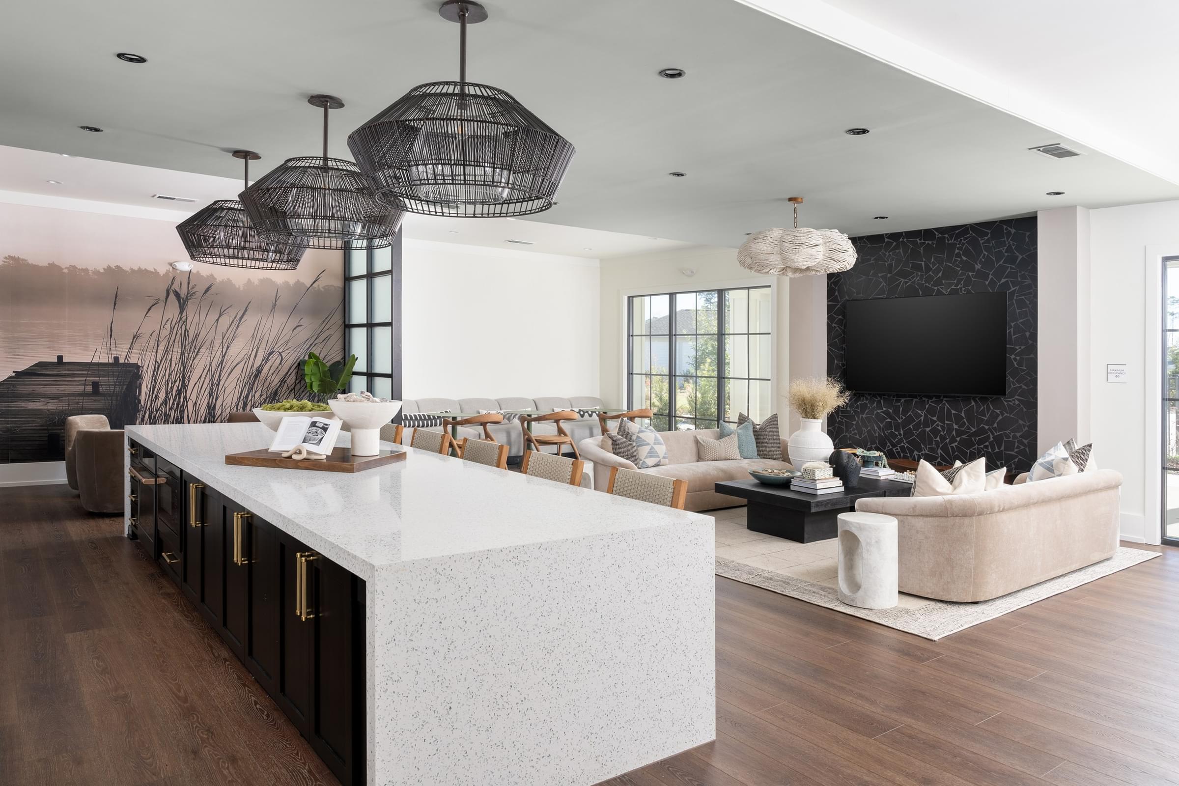 A modern living room with a white kitchen island and a large TV.