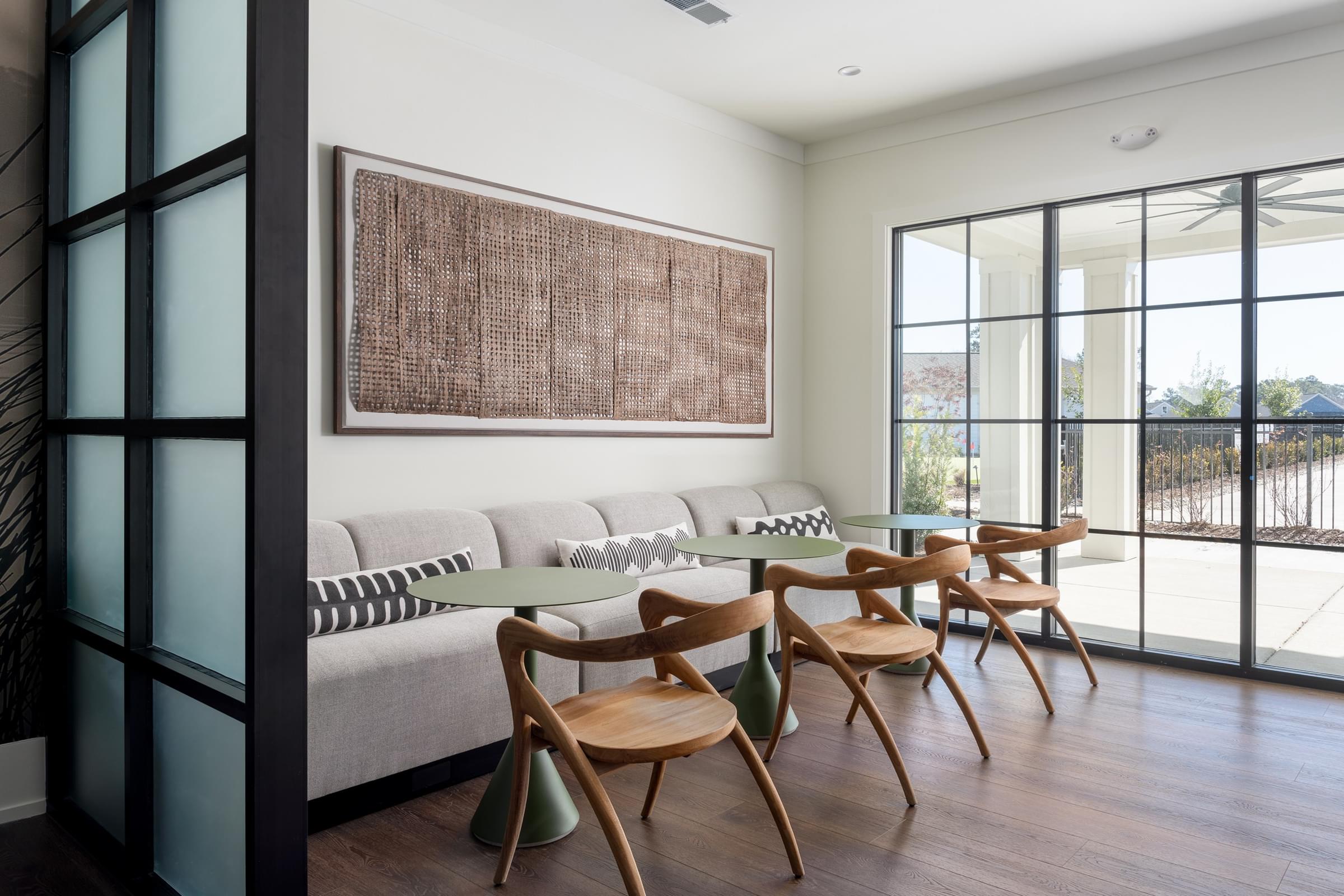 A living room with a couch, chairs, and a painting on the wall.