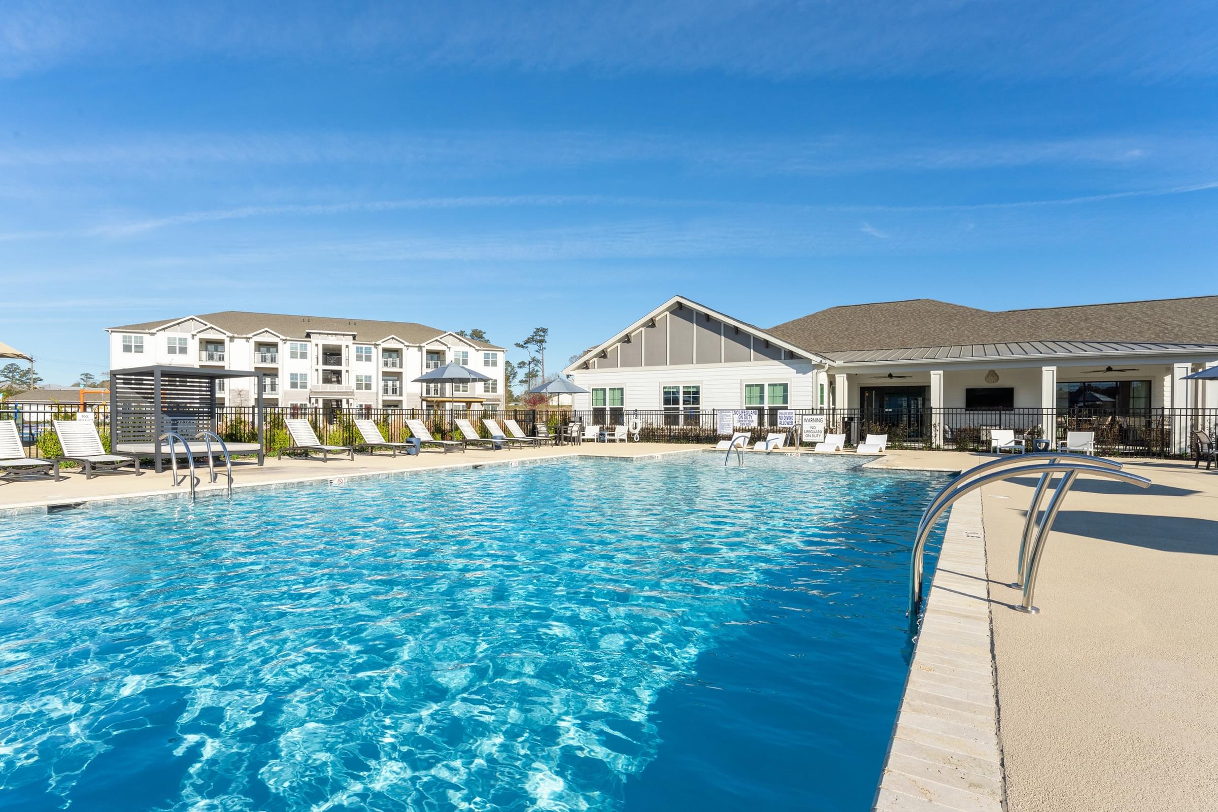 A large swimming pool in front of a resort.