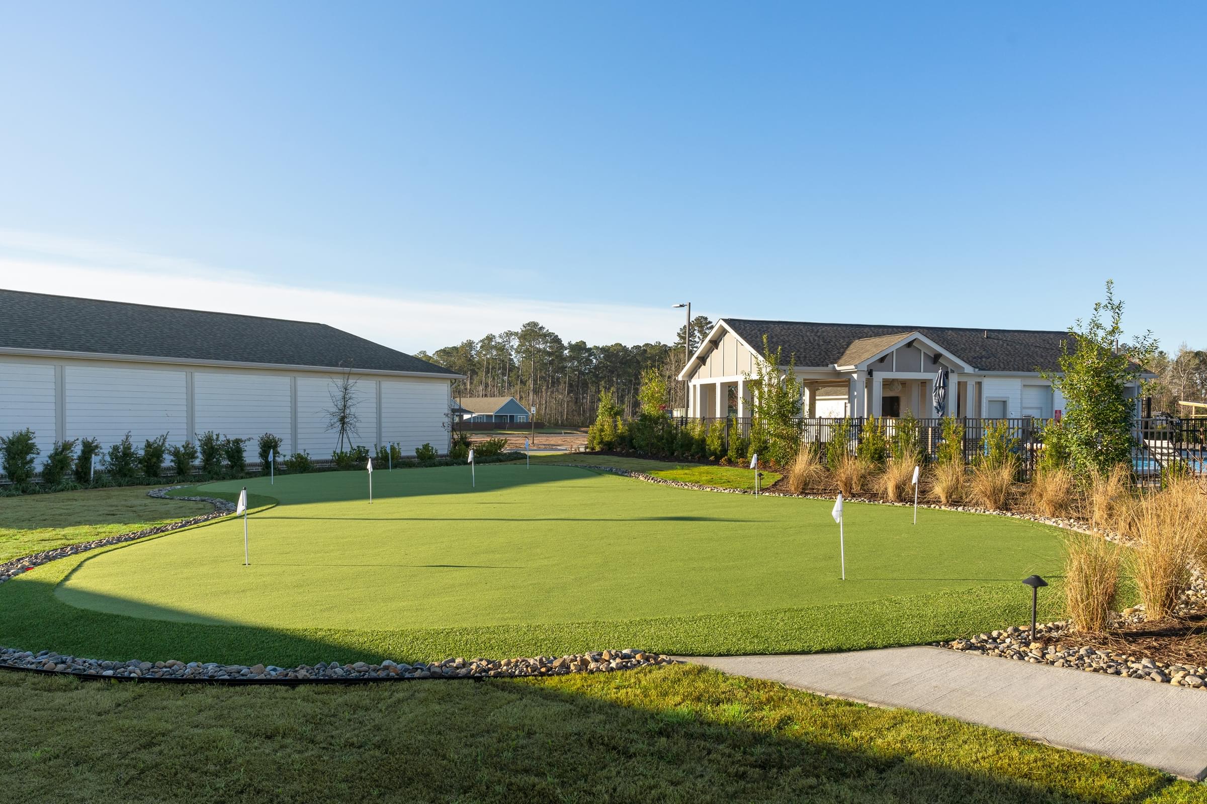 A golf course with a green and a flag on it.