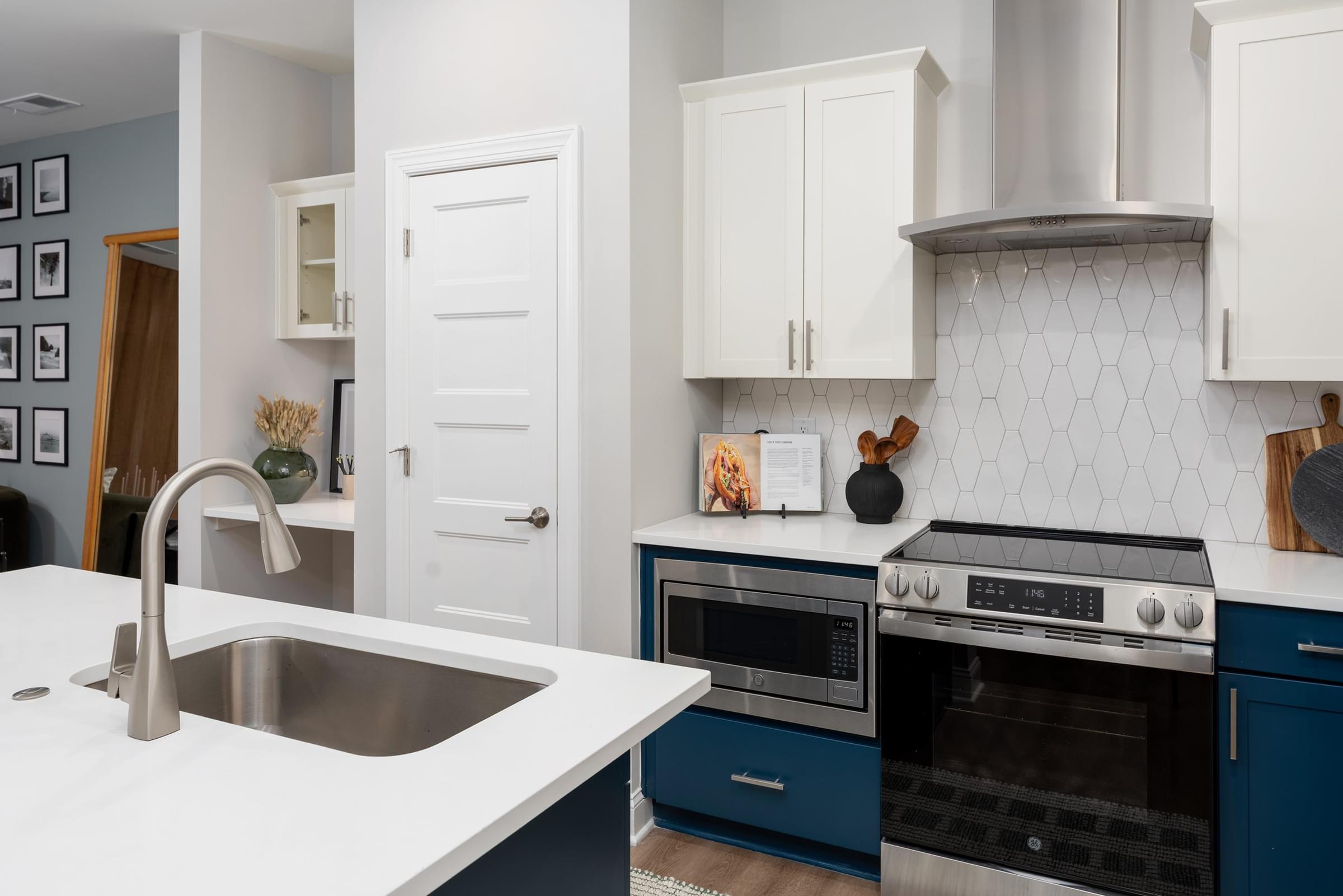 A kitchen with blue cabinets and a white countertop.