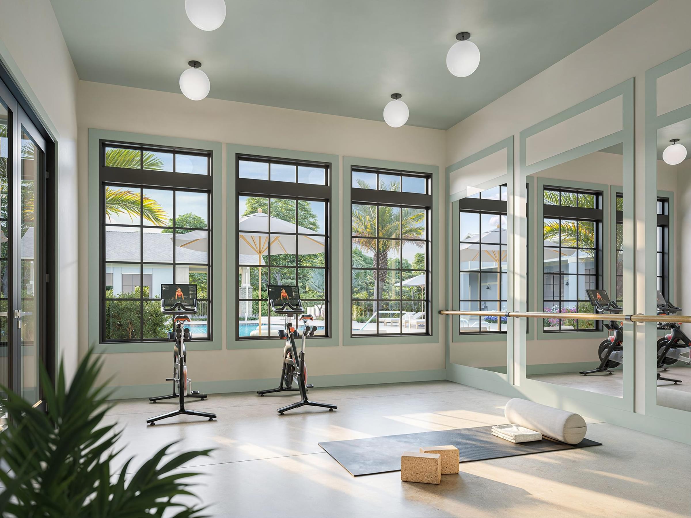 A room with exercise bikes and a yoga mat.
